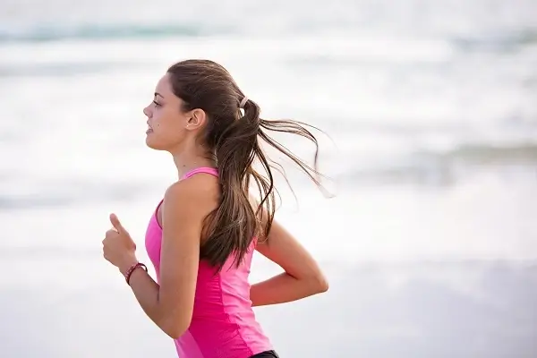 Solo female runner jogginh on beach